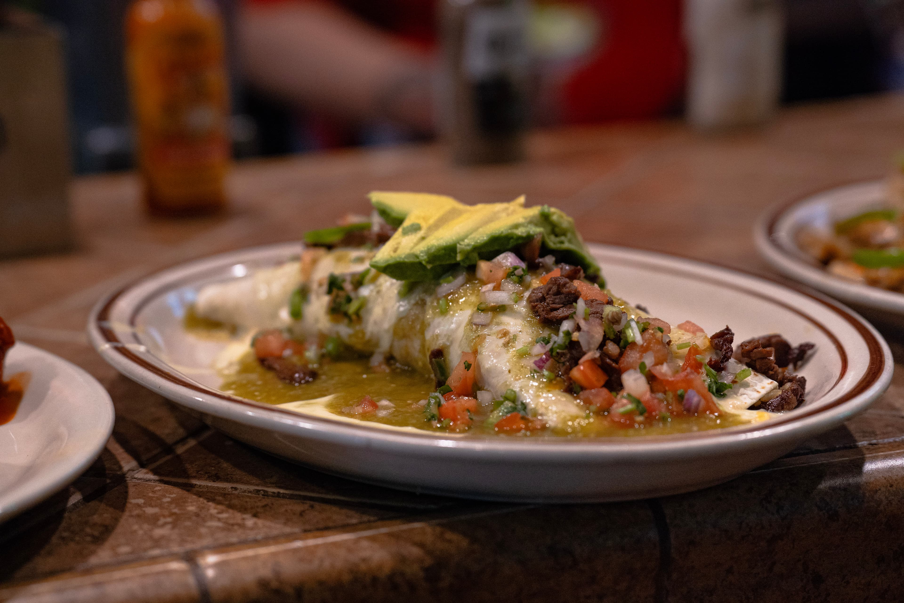 Green enchiladas topped with fresh avocado and cream